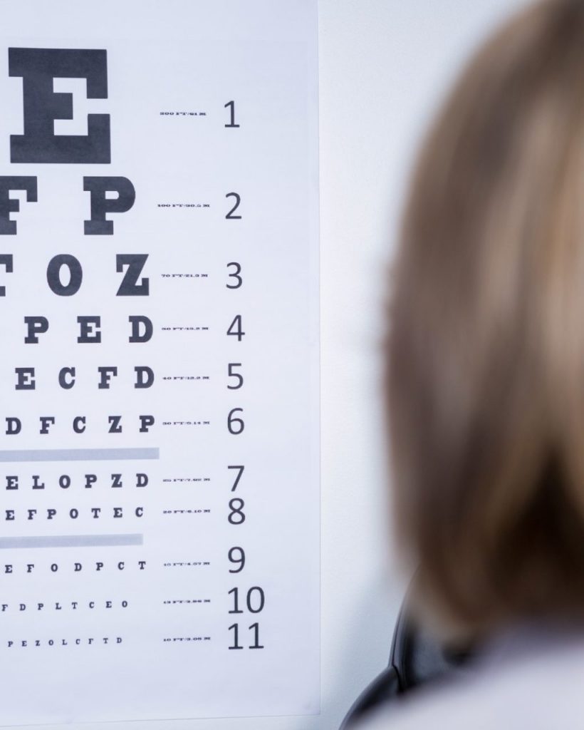 Optometrist looking at eye chart