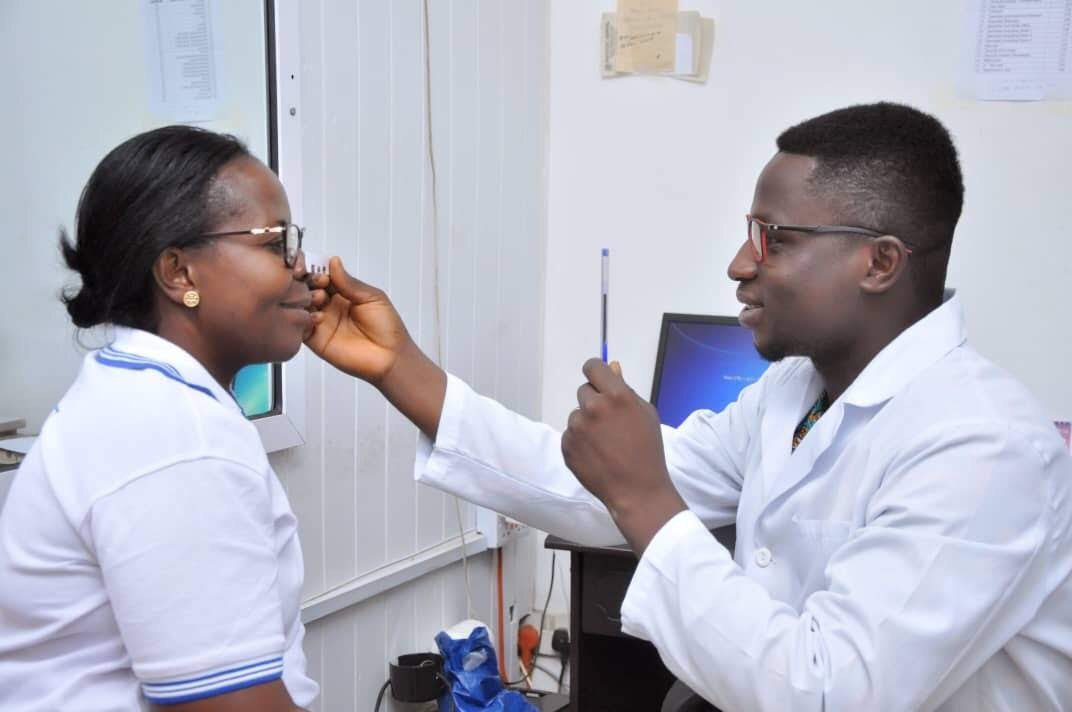 Young ophthalmologist is with little female visitor in the clinic